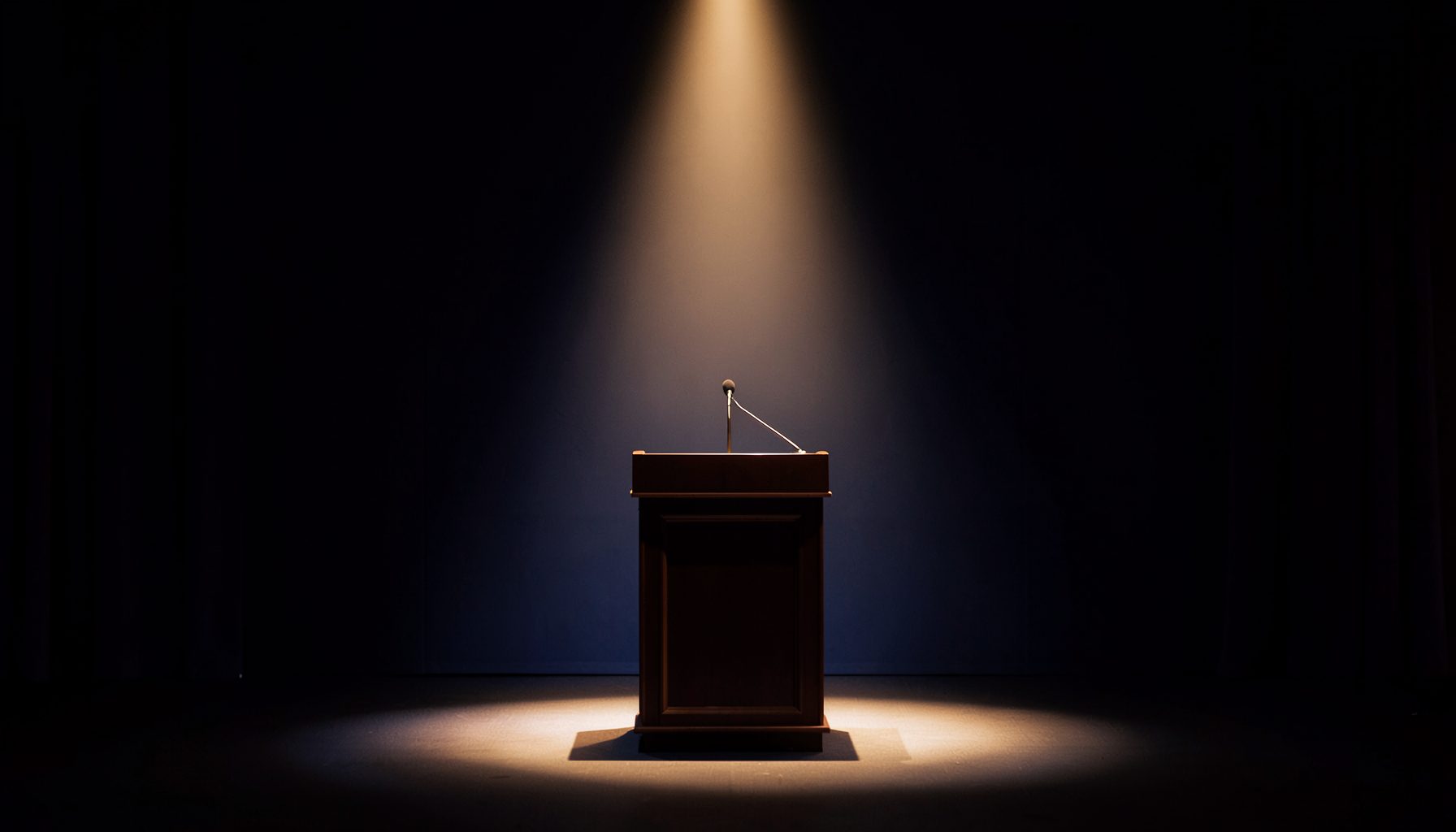 A softly lit conference stage with a single spotlight on an empty lectern, deep navy and warm amber tones, elegant and calm